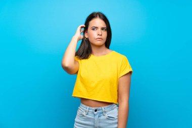 Izole mavi arka plan üzerinde genç kız şüpheleri olan