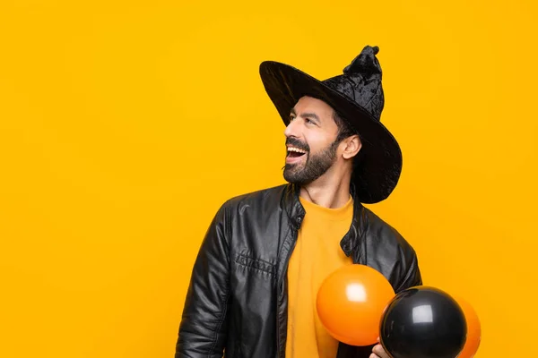 Człowiek Kapeluszu Czarownicy Trzyma Czarne Pomarańczowe Balony Powietrza Halloween Party — Zdjęcie stockowe