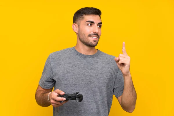 Joven Hombre Guapo Jugando Con Controlador Videojuegos Sobre Fondo Amarillo —  Fotos de Stock