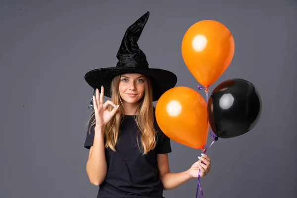 Young Witch Holding Black Orange Air Balloons Showing Sign Fingers — 스톡 사진