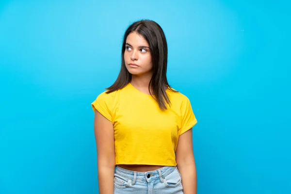 Menina Sobre Fundo Azul Isolado Fazendo Dúvidas Gesto Olhando Lado — Fotografia de Stock