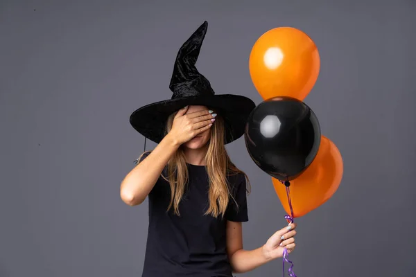 Молодая Ведьма Держит Черные Оранжевые Воздушные Шары Закрывающие Глаза Руками — стоковое фото