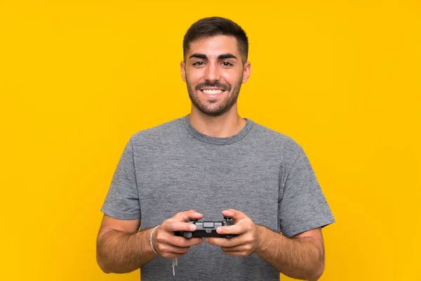 Joven Hombre Guapo Jugando Con Controlador Videojuegos Sobre Fondo Amarillo —  Fotos de Stock