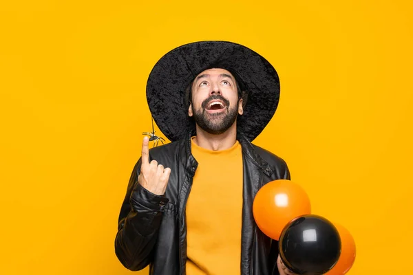 Człowiek Kapeluszu Czarownicy Trzymając Czarne Pomarańczowe Balony Powietrza Halloween Party — Zdjęcie stockowe