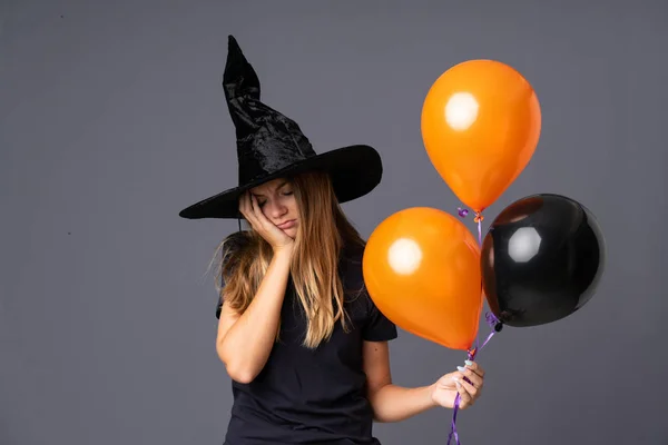 Bruxa Jovem Segurando Balões Preto Laranja Com Dúvidas Com Expressão — Fotografia de Stock