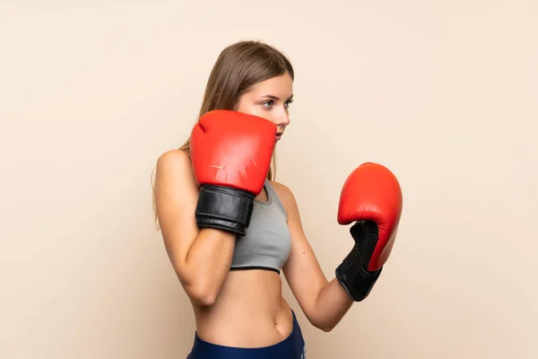 Menina loira jovem com luvas de boxe sobre fundo isolado — Fotografia de Stock