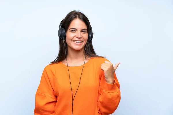 Jeune Femme Écoutant Musique Avec Mobile Sur Mur Bleu Isolé — Photo