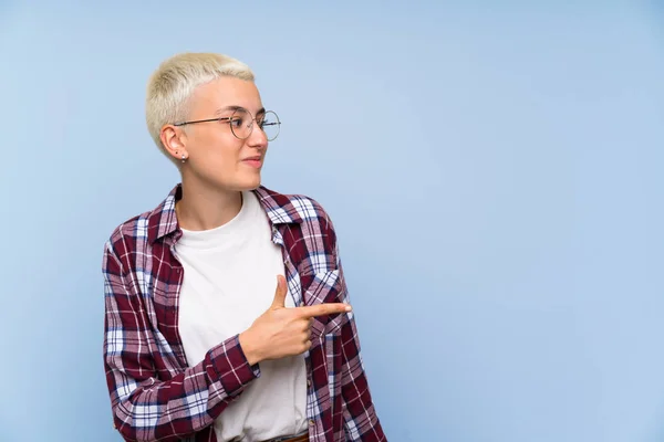 Adolescente Chica Con Pelo Corto Blanco Sobre Pared Azul Señalando —  Fotos de Stock