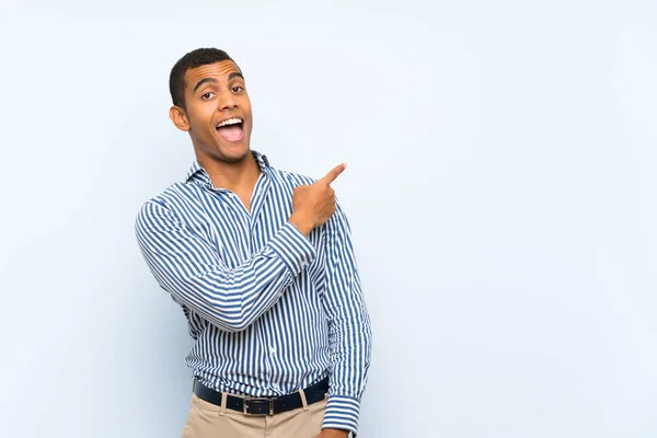 Joven Guapo Morena Hombre Sobre Aislado Azul Fondo Sorprendido Apuntando — Foto de Stock