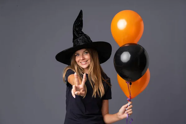 Joven Bruja Sosteniendo Globos Aire Negro Naranja Sonriendo Mostrando Señal —  Fotos de Stock