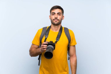 Genç fotoğrafçı kollarını kavuşturuyor.