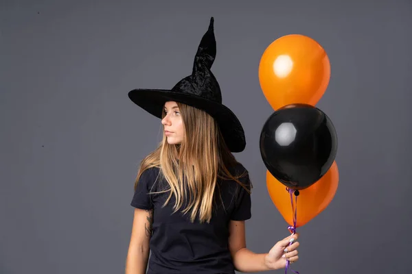 Mladá Čarodějnice Drží Černé Oranžové Vzduchové Balónky Hledá Stranu — Stock fotografie