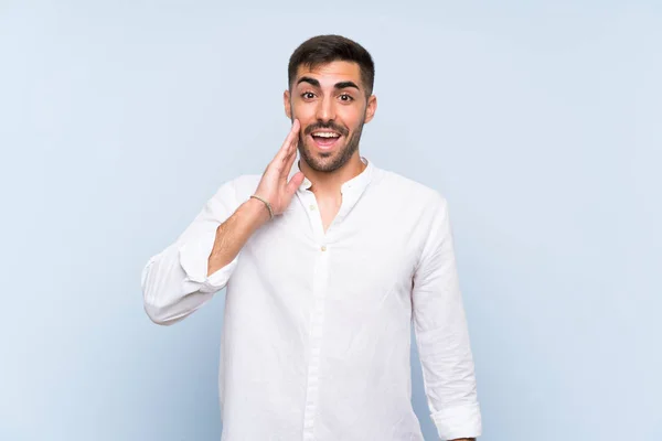 Hombre Guapo Con Barba Sobre Fondo Azul Aislado Con Sorpresa — Foto de Stock