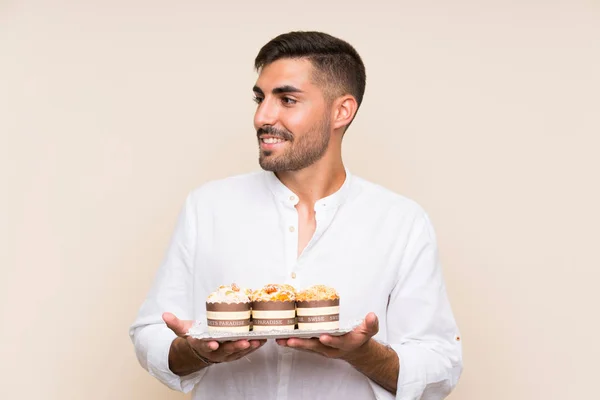Knappe Man Vasthouden Muffin Cake Geïsoleerde Achtergrond — Stockfoto