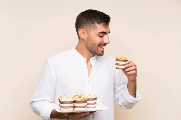 Handsome Man Holding Muffin Kaka Över Isolerad Bakgrund — Stockfoto