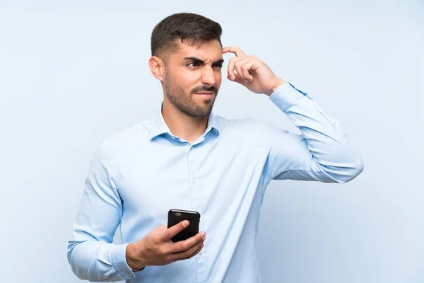 Junger Gutaussehender Mann Mit Handy Über Isolierter Blauer Wand Mit — Stockfoto