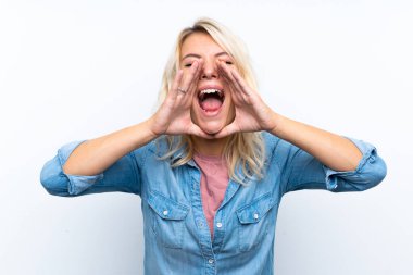İzole edilmiş beyaz arka planda genç sarışın kadın bağırıyor ve bir şeyler söylüyor.