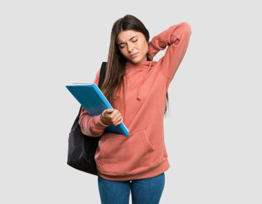 Gri arkaplanı boynu olan not defterleri tutan genç bir bayan öğrenci.