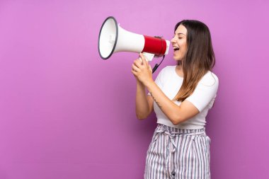 Mor arka plandan izole edilmiş genç bir kadın megafondan bağırıyor.