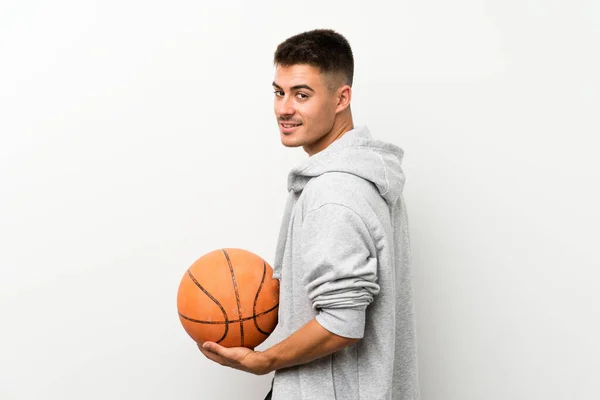 Hombre deportivo sobre pared blanca aislada con pelota de baloncesto —  Fotos de Stock