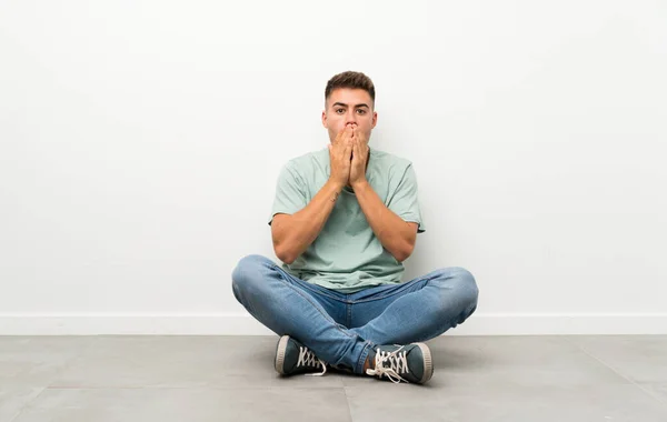 Joven Hombre Guapo Sentado Suelo Con Expresión Facial Sorpresa —  Fotos de Stock