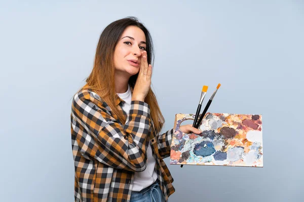 Jonge Schilder Vrouw Geïsoleerde Blauwe Achtergrond Fluisteren Iets — Stockfoto