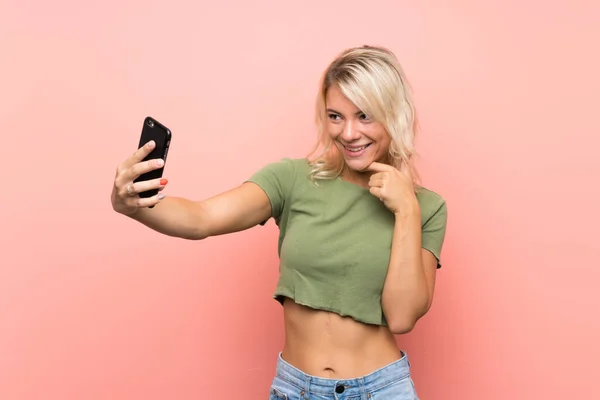 Joven Rubia Sobre Fondo Rosa Aislado Haciendo Una Selfie — Foto de Stock