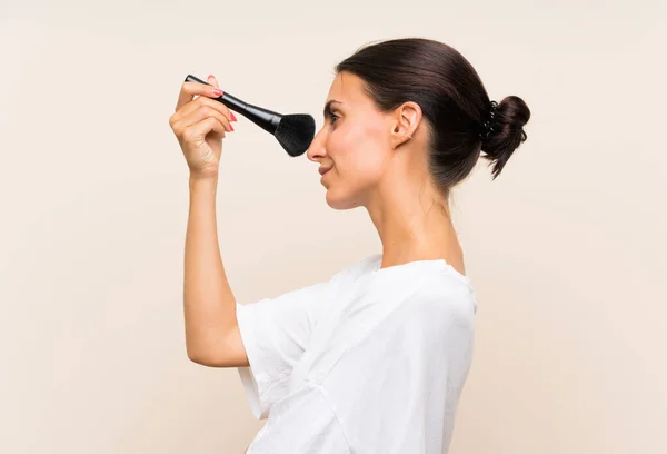 Mujer joven sosteniendo un cepillo de maquillaje — Foto de Stock