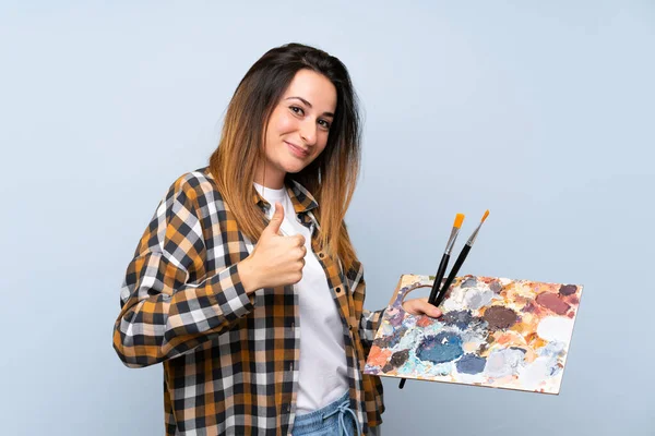 Joven Pintora Mujer Sobre Fondo Azul Aislado Con Pulgares Hacia — Foto de Stock