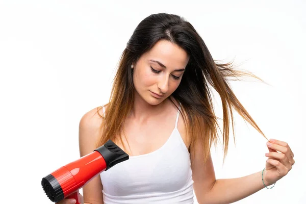 Young woman with hairdryer over isolated background — Stock Photo, Image