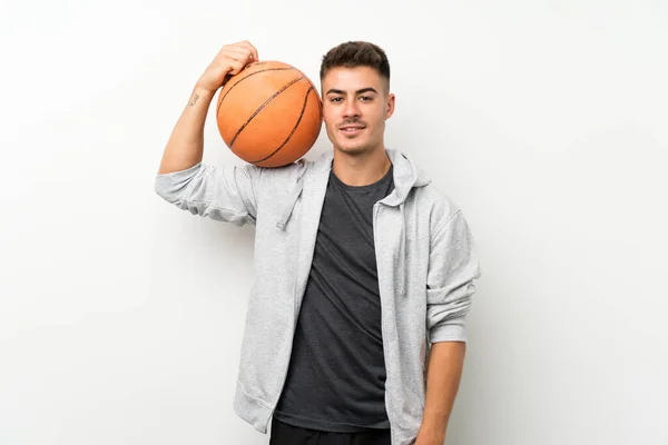 Sport man over isolated white wall with ball of basketball — Stock Photo, Image