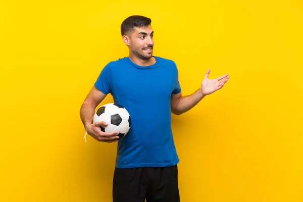 Молодой Красивый Футболист Над Изолированной Желтой Стеной Неожиданным Выражением Лица — стоковое фото