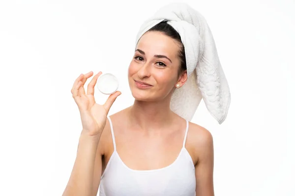 Young woman with moisturizer over isolated white background — Stock Photo, Image