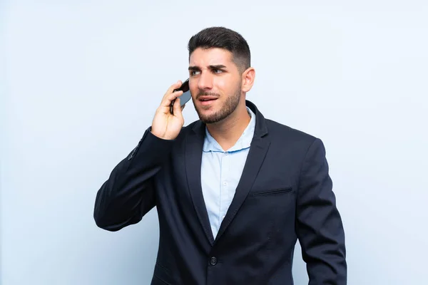 Hombre Guapo Sobre Fondo Azul Aislado Manteniendo Una Conversación Con —  Fotos de Stock