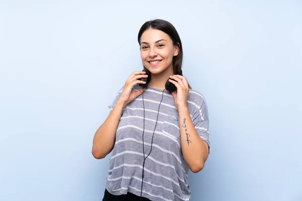 Joven Morena Sobre Fondo Azul Aislado Escuchando Música Con Auriculares —  Fotos de Stock