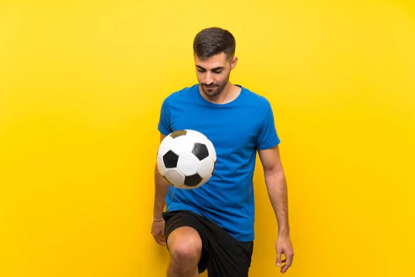 Jonge knappe voetballer man over geïsoleerde gele muur — Stockfoto
