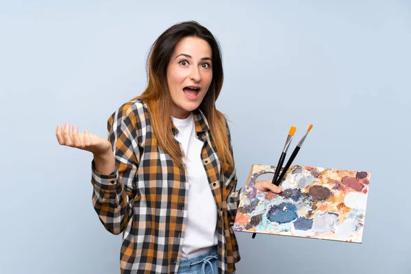 Jovem Pintor Mulher Sobre Fundo Azul Isolado Com Expressão Facial — Fotografia de Stock