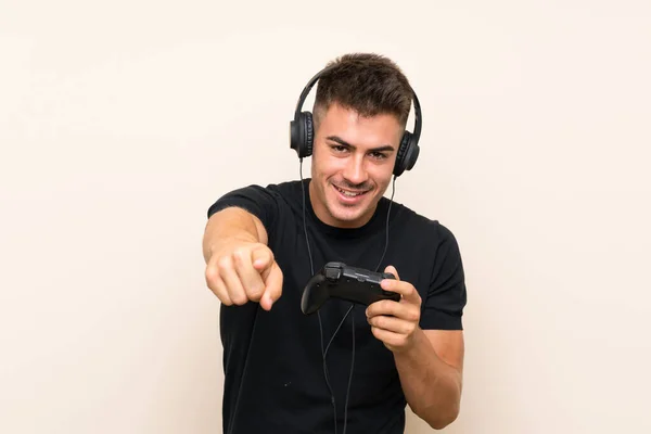 Joven hombre guapo jugando con un controlador de videojuegos sobre un fondo aislado —  Fotos de Stock