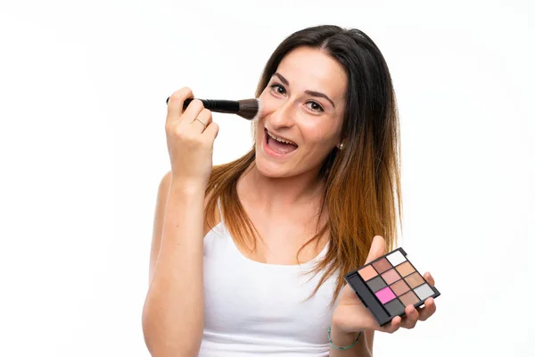 Mujer joven con cepillo de maquillaje sobre fondo blanco aislado — Foto de Stock