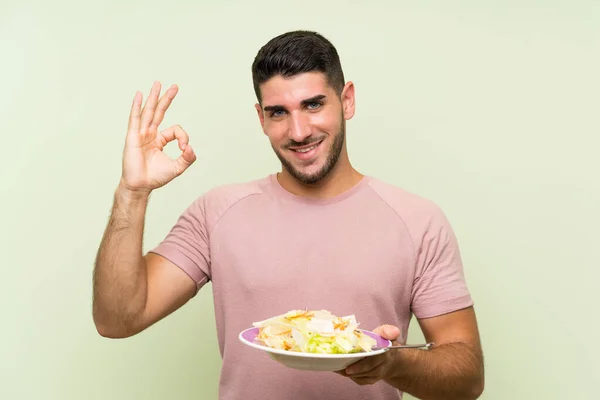 Young Handsome Man Salad Isolated Green Wall Showing Sign Fingers — Stock Photo, Image