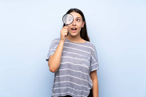 Ung Brunett Kvinna Över Isolerad Blå Bakgrund Håller Ett Förstoringsglas — Stockfoto