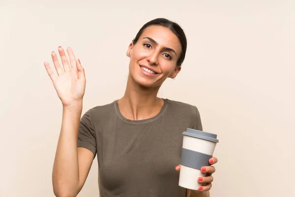 Mladá Žena Drží Odnést Kávu Salutování Rukou Šťastným Výrazem — Stock fotografie