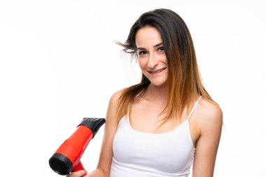Izole arka plan üzerinde saç kurutma makinesi ile genç kadın