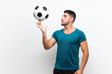 Izole beyaz duvar üzerinde Yakışıklı genç futbolcu adam 