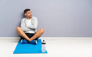 Spor adam bir yerde gülerek oturuyor