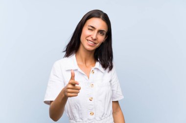 Izole mavi arka plan üzerinde genç kadın size parmak