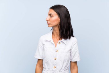 İzole mavi arka plan görünümlü yan üzerinde genç kadın