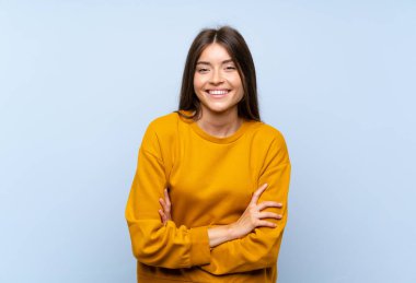 Izole mavi duvar üzerinde beyaz genç kadın gülüyor