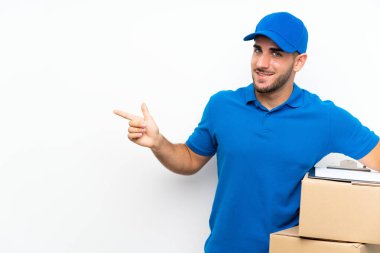 Delivery man over isolated white background pointing finger to the side clipart