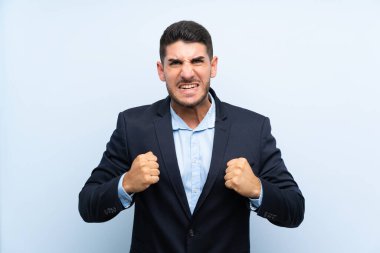 Soyutlanmış mavi arka planda yakışıklı bir adam kötü bir durum yüzünden hayal kırıklığına uğramış.